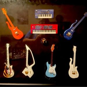 Shadow box featuring various Prince miniature guitars and key boards